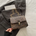 Leopard print crossbody bag with gold chain strap on grey blazer and white sheets - Khaki