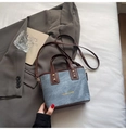 Secchiello vintage in denim con finiture in pelle marrone e borchie dorate su letto bianco - Blu