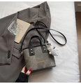 Grey canvas bucket bag with black leather trim, gold studs and fuzzy charm accessory - Black With Pendant