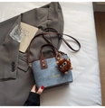 Denim blue bucket bag with brown leather handles and a plush monster charm - Blue with Pendant