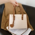 Minimalistische weiße Stepphandtasche mit braunen Lederakzenten und Herzanhänger - Beige