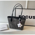 Dettaglio della borsa tote in pelle scamosciata grigia con finiture nere e ciondolo a stella - Con Ciondolo / Marrone Scuro