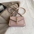 Dusty rose leather handbag with gold metal clasp and adjustable strap in a stylish setup - Pink