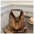 Detail eines dunkelbraunen Vintage-Lederrucksacks mit zwei silbernen Reißverschlüssen - Braun