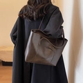Retro dark brown tote bag with shoulder strap shown on a model wearing a black coat - Coffee