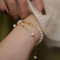 Elegante geschichtete Goldperlenarmbänder mit geometrischen Perlen am Handgelenk - Doppellagiges Design