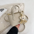 Beige lychee pattern bucket bag with cute monkey charm and gold hardware strap - Sand