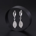 Elegant silver leaf hoop earrings with shimmering white zircon pavé on black background - Simple Zircon Leaf Hoop Earrings (EH-620) / Silver