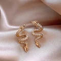 Elegante goldene Schlangenohrringe mit Zirkon-Besatz auf Champagner-Satin-Stoff - Gold