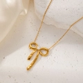 Exquisite golden bow pendant necklace with a white pearl on a textured white stone surface - Gold Bowknot Pearl