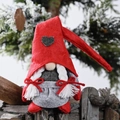 Weihnachtswichtel Puppe mit rotem Herz-Hut und weißen Zöpfen vor Winterhintergrund - Weiblich (Zöpfe)