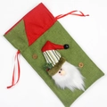Green burlap Christmas gift bag featuring a plush Santa Claus with red stripe hat - Santa Claus