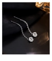 Macro shot of S925 sterling silver rose drop earrings with delicate chain on silk background - White Gold
