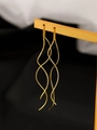 Detailed view of long gold spiral pull-through earrings on a dual-tone display stand - Wave Ear Thread / Gold