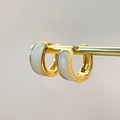 Gedetailleerde weergave van vintage gouden oorringen met wit emaille inleg en C-vormig design - Wit