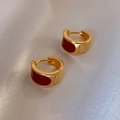 Vintage geometrische gouden oorringen met donkerrood emaille op een zijden achtergrond - Bordeauxrood