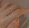 Macro shot of gold intertwined vine ring with sparkling cubic zirconia on finger - Adjustable Open / Gold
