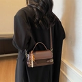 Dark brown matte crossbody bag with wooden bead pendant shown on a model - With Pendant / Coffee