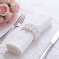 Elegant white pearl beaded napkin ring on lace tablecloth with dinnerware for wedding decor - White