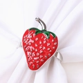 Macro shot of red enamel strawberry napkin ring with green leaves on silver metal - Silver