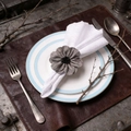 Handmade grey fabric flower napkin ring with black bead center on an elegant table setting - Gray