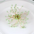 Macro view of a handmade gold wire napkin ring with faceted light green crystal beads - Light Green