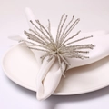 Macro shot of silver beaded napkin ring featuring a radiating firework tassel design - White