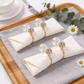 Golden napkin rings set with crystal ball and rhinestones on white napkins - Gold