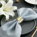 Elegante gouden kroon servetring op blauw linnen met witte lelies aan de zijkant - Mat Goud