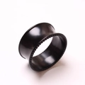 Vista macro de túnel de oreja negro pulido con borde perlado para piercing de oreja - Borde de Cuentas Negro