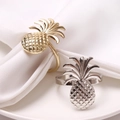 Lot de ronds de serviette ananas en or et argent poli sur des assiettes blanches - Doré