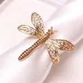 Elegant gold dragonfly napkin ring with hollow wings on a white napkin holder - Gold