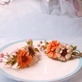 Set di portatovaglioli con margherite finte arancioni e crema in un piatto di ceramica bianca - Girasole Arancione e Beige