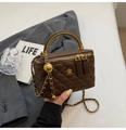 Nahaufnahme der braunen Stepp-Kosmetiktasche mit goldener Kette und Griffdetail - Kaffeebraun
