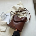 Dark brown leather bucket bag with woven handle and vintage texture detail - Brown