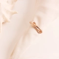 Rond de serviette nœud infini en métal or rose sur un fond de tissu texturé élégant - Doré