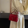 Elegante borsa a tracolla rossa con fibbia a V dorata indossata per uno stile quotidiano - Borgogna
