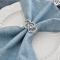 Silver double heart napkin ring with twisted rope texture on a blue linen napkin - Double Heart Twisted Texture Style / Silver