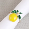 Vibrant yellow lemon napkin ring with green leaves and a polished golden metal base - Style 5 (Round Lemon)