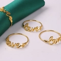 Lot de quatre ronds de serviette Love dorés avec forme de cœur sur satin vert - Style Lettre Love Coeur / Doré