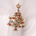 Servilletero de árbol de Navidad dorado con pedrería de colores sobre servilleta blanca - Árbol de Navidad de Diamante de Color