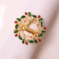 Christmas reindeer napkin ring with green wreath and red berries on a white cloth - Gold Christmas Reindeer Wreath Style