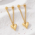 Detail von goldenen Herz-Ohrringen mit Kette und Polierung auf sandigem Hintergrund - Gold (C5025)