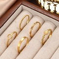 Detail of five gold geometric stainless steel rings displayed in a luxury velvet jewelry box - 5-Piece Set (Gold) / Gold (C9911)