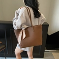 Brown leather tote bag with lychee texture and decorative scarf worn by a model - Coffee