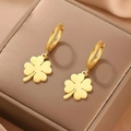 Elegantes pendientes de trébol de acero inoxidable dorado sobre cuero oscuro - Dorado