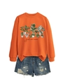 Detail of orange crewneck sweatshirt featuring watercolor potted plant prints and text - Orange Sweatshirt (Black Text Graphic)