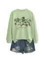 Detail view of mint green crewneck sweatshirt with botanical print and denim shorts - Olive Green Sweatshirt (Black Text)