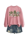 Close-up of pink crewneck sweatshirt with botanical plant print and distressed denim shorts - Rose Gold Sweatshirt (Black Text)