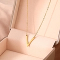 Detailansicht einer goldenen V-Halskette auf einer rosa Seiden-Schmuckschatulle - Gold